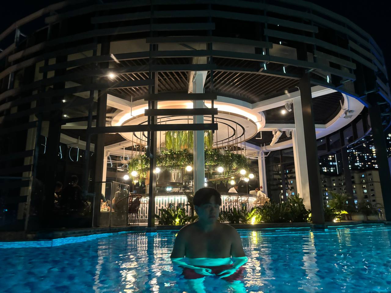 Momentus Hotel Alexandra pool area, featuring a pristine swimming pool surrounded by lounge chairs and lush greenery